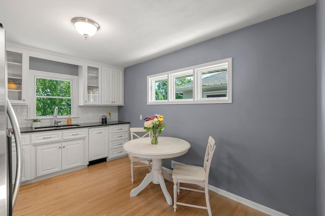5625 Upton Ave S, Minneapolis, MN 55410 - kitchen with healthy amount of natural light, backsplash, white cabinets, and light wood-type flooring