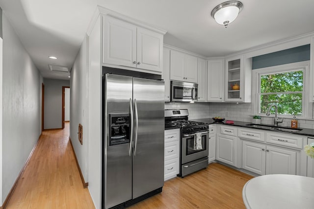 5625 Upton Ave S, Minneapolis, MN 55410 - kitchen featuring stainless steel appliances, dark countertops, light wood-style floors, and backsplash