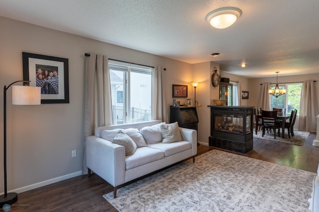 4408 Riverwood Dr N, Fargo, ND 58102 - living room with dark wood-style flooring, a chandelier, baseboards, and a textured ceiling