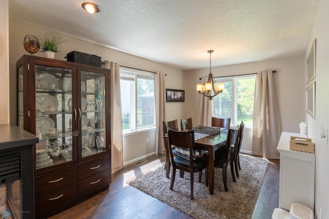 4408 Riverwood Dr N, Fargo, ND 58102 - dining area featuring healthy amount of natural light, dark wood-style floors, a textured ceiling, a chandelier, and baseboards