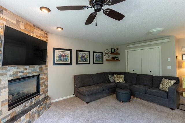 4408 Riverwood Dr N, Fargo, ND 58102 - carpeted living area featuring a textured ceiling, a fireplace, a ceiling fan, and baseboards