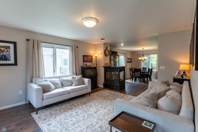 4408 Riverwood Dr N, Fargo, ND 58102 - living room with dark wood finished floors, a chandelier, baseboards, and a textured ceiling
