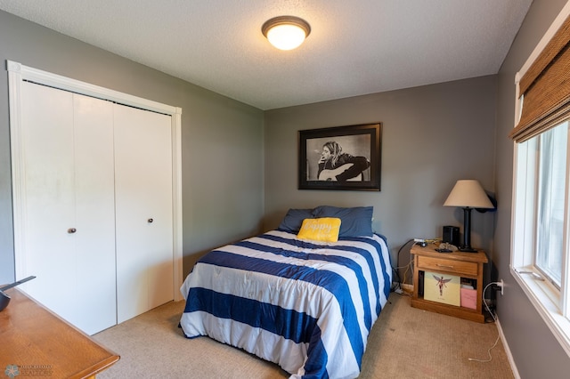 4408 Riverwood Dr N, Fargo, ND 58102 - bedroom with carpet flooring, multiple windows, a closet, a textured ceiling, and baseboards