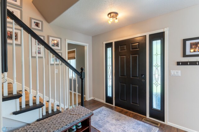 4408 Riverwood Dr N, Fargo, ND 58102 - entrance foyer with stairs, plenty of natural light, baseboards, dark wood finished floors, and a textured ceiling