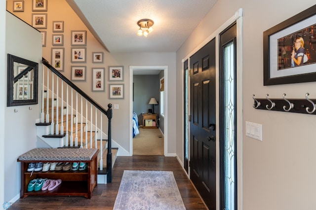 4408 Riverwood Dr N, Fargo, ND 58102 - entrance foyer with dark wood-type flooring, stairway, baseboards, and a textured ceiling