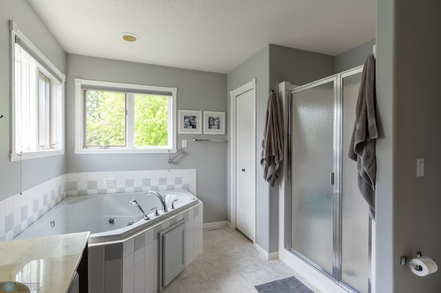 4408 Riverwood Dr N, Fargo, ND 58102 - full bathroom featuring a shower stall, a tub with jets, a textured ceiling, baseboards, and vanity