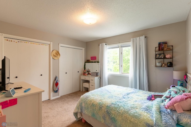 4408 Riverwood Dr N, Fargo, ND 58102 - bedroom featuring two closets, light carpet, and a textured ceiling