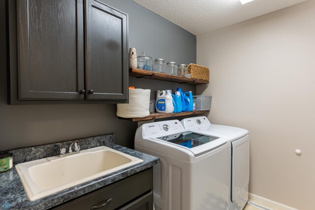 4408 Riverwood Dr N, Fargo, ND 58102 - washroom with washer and clothes dryer, cabinet space, and a textured ceiling