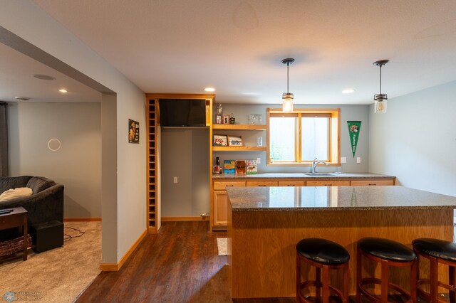 4408 Riverwood Dr N, Fargo, ND 58102 - kitchen featuring a sink, a kitchen bar, dark wood-style flooring, decorative light fixtures, and recessed lighting