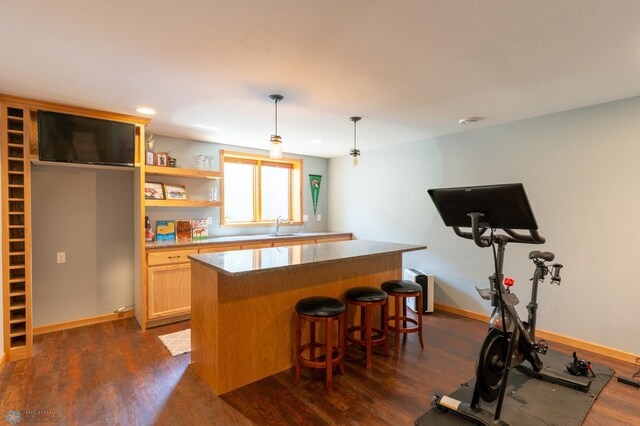 4408 Riverwood Dr N, Fargo, ND 58102 - kitchen with dark wood finished floors, a center island, baseboards, a kitchen breakfast bar, and hanging light fixtures