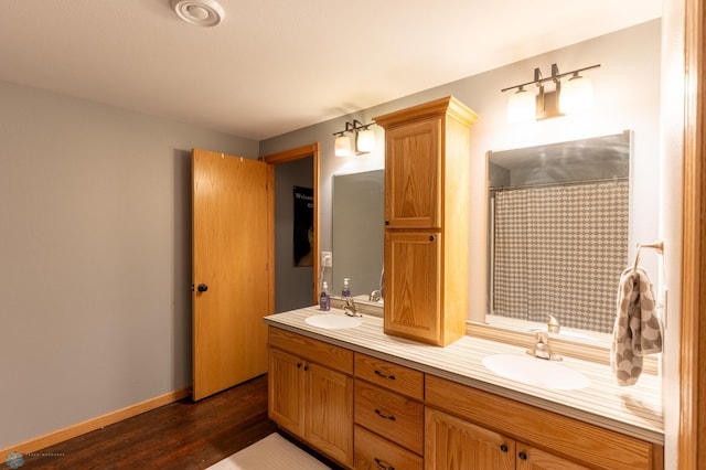 4408 Riverwood Dr N, Fargo, ND 58102 - full bathroom featuring double vanity, wood finished floors, and baseboards
