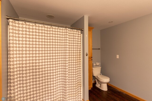 4408 Riverwood Dr N, Fargo, ND 58102 - full bath featuring toilet, wood finished floors, curtained shower, and baseboards