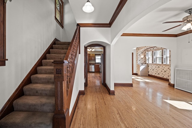 2059 Iglehart Ave, Saint Paul, MN 55104 - staircase featuring ceiling fan, arched walkways, ornamental molding, wood finished floors, and healthy amount of natural light