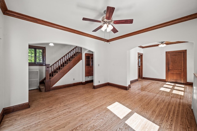 2059 Iglehart Ave, Saint Paul, MN 55104 - unfurnished living room with arched walkways, ceiling fan, baseboards, light wood-style flooring, and ornamental molding