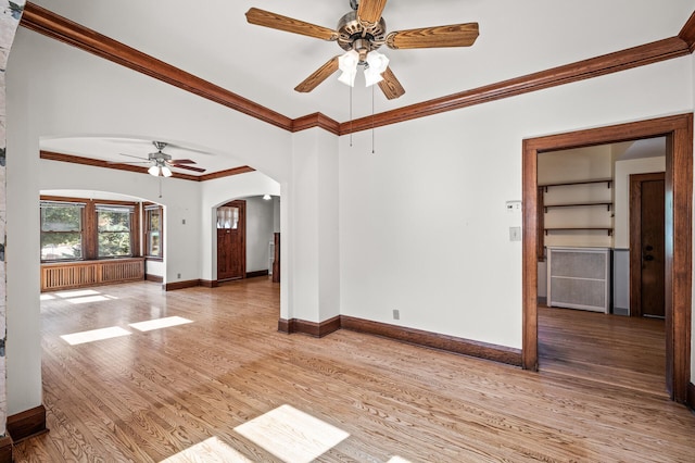 2059 Iglehart Ave, Saint Paul, MN 55104 - unfurnished room featuring a ceiling fan, arched walkways, ornamental molding, light wood-style floors, and baseboards