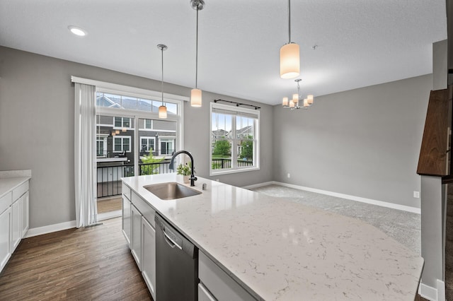 5040 93rd Ln N, Brooklyn Park, MN 55443 - kitchen with stainless steel dishwasher, a sink, baseboards, a chandelier, and light stone countertops