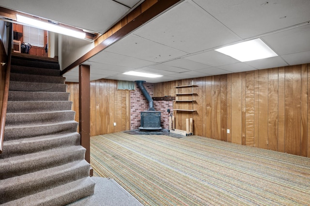 5030 Jefferson St NE, Columbia Heights, MN 55421 - finished basement featuring a wood stove, carpet floors, wooden walls, stairs, and a drop ceiling