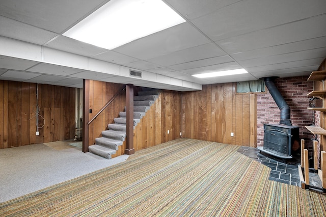 5030 Jefferson St NE, Columbia Heights, MN 55421 - finished below grade area featuring a wood stove, carpet floors, stairs, wooden walls, and a paneled ceiling