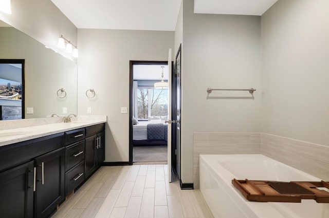 2524 Sandstone Ln, Orono, MN 55356 - ensuite bathroom with double vanity, a bath, and baseboards