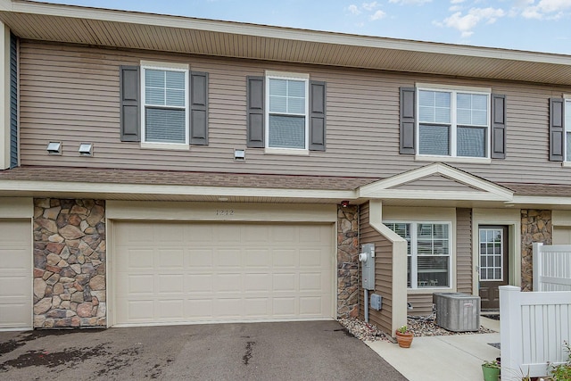 1212 Lower 143rd St E, Rosemount, MN 55068 - view of property with stone siding, cooling unit, a garage, and asphalt driveway