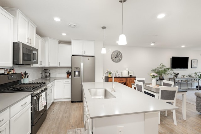 1212 Lower 143rd St E, Rosemount, MN 55068 - kitchen with stainless steel appliances, light wood-style flooring, an island with sink, light countertops, and recessed lighting