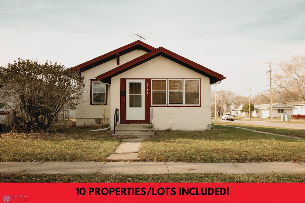 1044 16th St N, Fargo, ND 58102 - bungalow-style home with entry steps, a front yard, and stucco siding