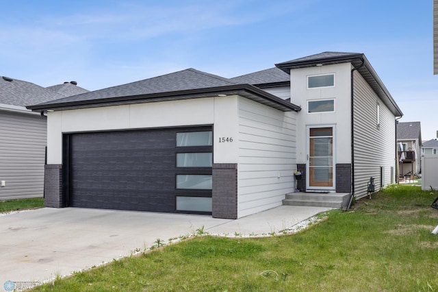 1546 68th Ave S, Fargo, ND 58104 - view of front facade with a garage, concrete driveway, roof with shingles, and a front yard