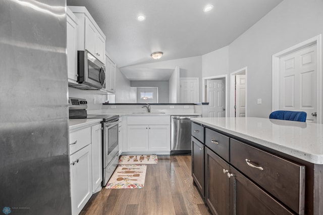 1546 68th Ave S, Fargo, ND 58104 - kitchen with stainless steel appliances, a sink, dark wood-style floors, a peninsula, and white cabinets