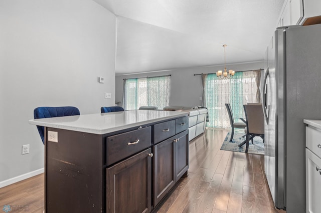 1546 68th Ave S, Fargo, ND 58104 - kitchen featuring freestanding refrigerator, a chandelier, wood finished floors, dark brown cabinets, and open floor plan