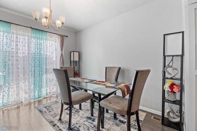 1546 68th Ave S, Fargo, ND 58104 - dining room with a chandelier, wood finished floors, and baseboards