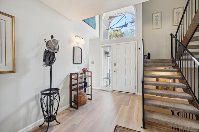 1198 Saint Clair Ave, Saint Paul, MN 55105 - foyer featuring stairs, light wood finished floors, baseboards, and a towering ceiling