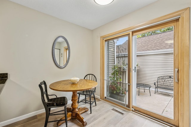 1198 Saint Clair Ave, Saint Paul, MN 55105 - dining room featuring wood finished floors, baseboards, and a textured ceiling