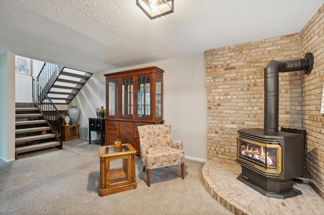 1198 Saint Clair Ave, Saint Paul, MN 55105 - living area featuring stairs, a textured ceiling, a wood stove, carpet flooring, and brick wall