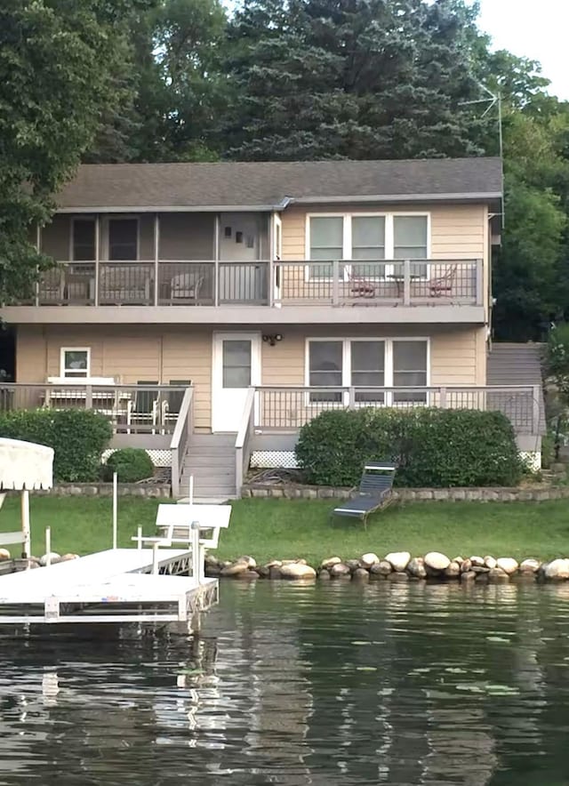 13394 77th St NW, Annandale, MN 55302 - view of front facade with a balcony, a water view, a boat dock, and a front lawn