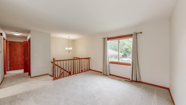 2209 18th Ave SE, Rochester, MN 55904 - empty room featuring light colored carpet, a chandelier, and baseboards