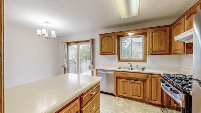 2209 18th Ave SE, Rochester, MN 55904 - kitchen featuring appliances with stainless steel finishes, a sink, brown cabinetry, light countertops, and under cabinet range hood