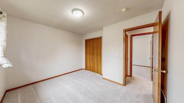 2209 18th Ave SE, Rochester, MN 55904 - unfurnished bedroom featuring light carpet, baseboards, a textured ceiling, and a closet