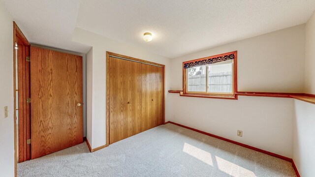 2209 18th Ave SE, Rochester, MN 55904 - unfurnished bedroom featuring carpet floors, a closet, and baseboards