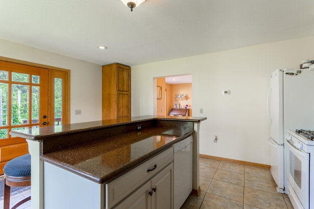 N8355 330th St, Gilman Twp, WI 54767 - kitchen with white appliances, a kitchen island, dark stone countertops, baseboards, and light tile patterned flooring