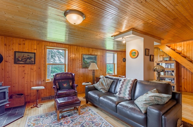 N8355 330th St, Gilman Twp, WI 54767 - living room featuring healthy amount of natural light, wood walls, hardwood / wood-style flooring, stairway, and a wood stove