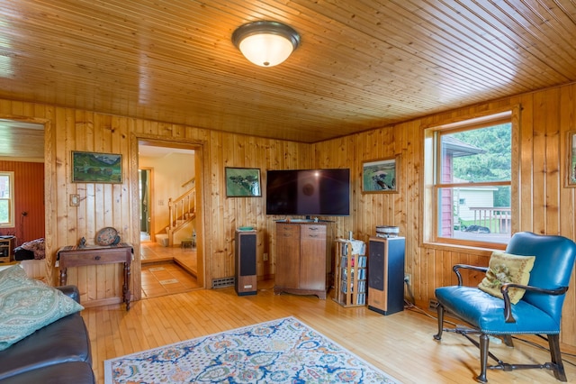 N8355 330th St, Gilman Twp, WI 54767 - living room featuring stairway, wooden walls, healthy amount of natural light, wooden ceiling, and light wood-style flooring