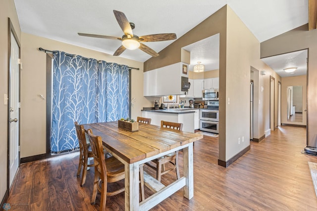 226 12th Ave W, West Fargo, ND 58078 - dining room featuring ceiling fan, baseboards, wood finished floors, and lofted ceiling