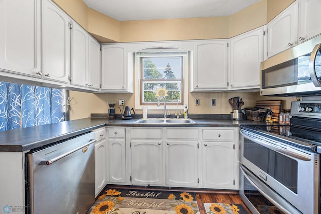 226 12th Ave W, West Fargo, ND 58078 - kitchen with stainless steel appliances, a sink, dark countertops, and white cabinetry