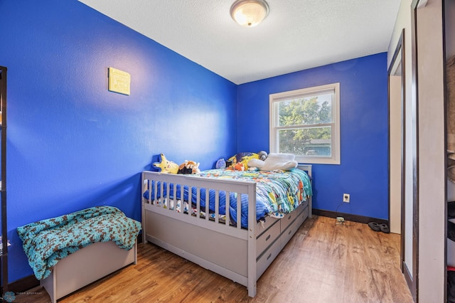 226 12th Ave W, West Fargo, ND 58078 - bedroom featuring wood finished floors, a textured ceiling, and baseboards