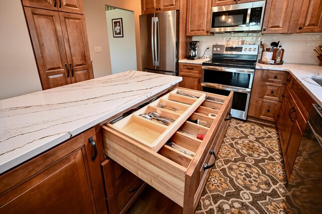 206 Skyline Hts, Wabasha, MN 55981 - kitchen with appliances with stainless steel finishes, tasteful backsplash, brown cabinets, and light stone counters