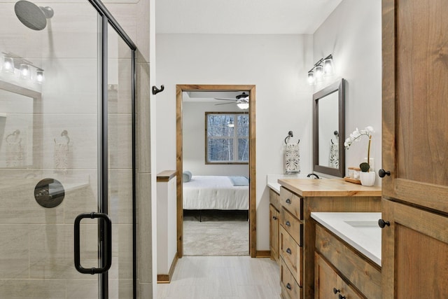 1843 Campfire Dr E, Waconia, MN 55387 - ensuite bathroom featuring two vanities, a shower stall, a ceiling fan, and baseboards