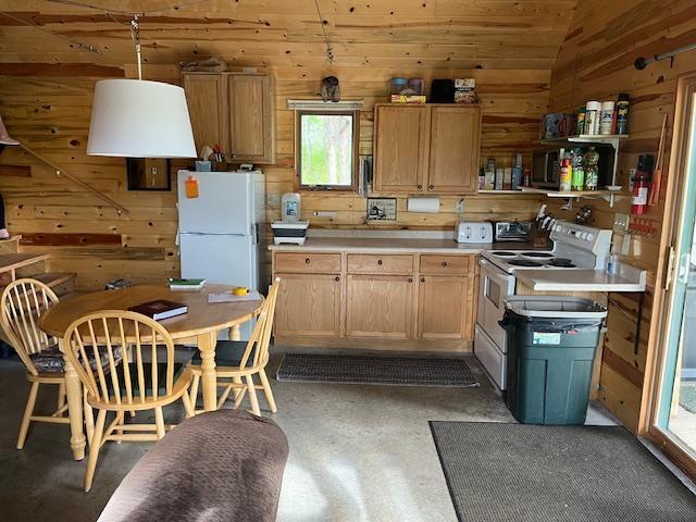 3573 Kallio Rd, Orr, MN 55771 - kitchen featuring white appliances, wood walls, lofted ceiling, light countertops, and open shelves