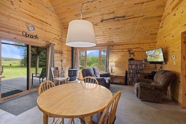 3573 Kallio Rd, Orr, MN 55771 - dining space with a wood stove, wood walls, plenty of natural light, high vaulted ceiling, and wooden ceiling