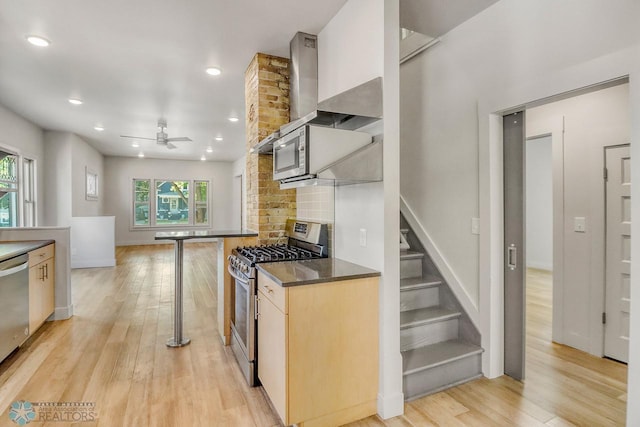 1036 12th St N, Fargo, ND 58102 - kitchen with stainless steel appliances, ceiling fan, dark countertops, light wood-style flooring, and backsplash