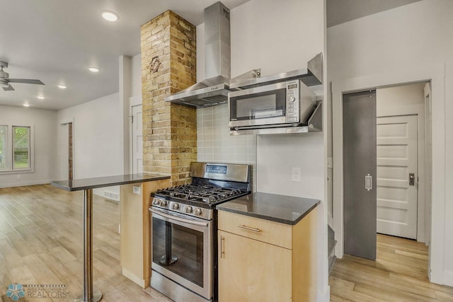 1036 12th St N, Fargo, ND 58102 - kitchen with stainless steel appliances, wall chimney exhaust hood, light wood-type flooring, tasteful backsplash, and recessed lighting